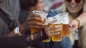 Close-up uf hands toasting in beer, at festival