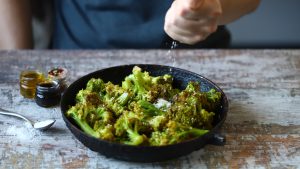 The chef sprinkles the broccoli.
