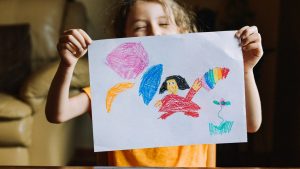 Little girl showing her drawing