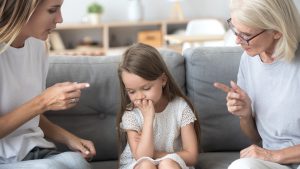 Angry mother and grandmother scolding lecturing upset kid girl together