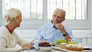 Happy senior couple having breakfast at table