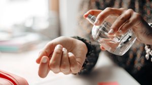 Woman spraying perfume on wrist