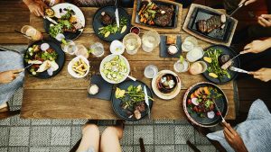 Medium overhead shot of families sharing dinner at outdoor restaurant