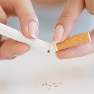 Close up of Hispanic woman breaking cigarette