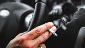 Detail Of A Smoking Man In His Car