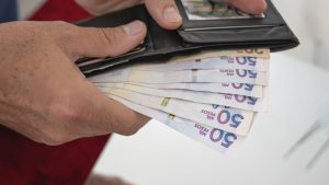 Man's hands Holding Wallet and Colombian Pesos Bills
