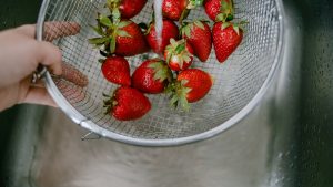 High angle view of rinsing strawberries in kitchen sink