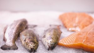 Salmon on ice, waiting to be sold, in market stall