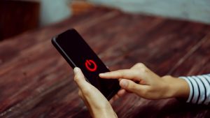 Woman hand using smartphone to switch off or shut down online and social connection. Business, financial, trade stock maket and social network concept.
