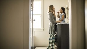 Mother and daughter (7yrs) brushing teeth in bathroom
