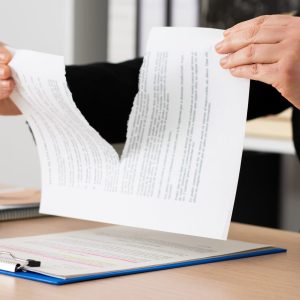 businesswoman tearing up the signed contract