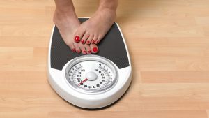 Obese woman weighing herself