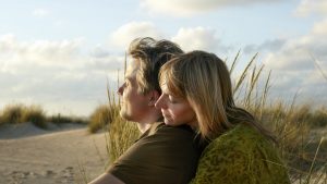 couple sitting embracing on beach
