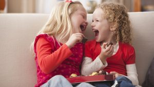 Caucasian girls eating Valentine's candy