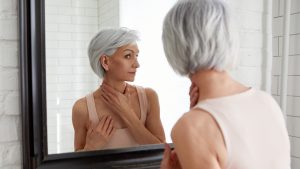 Elderly woman at mirror in bathroom