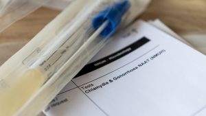 A sample container and medical form for a Chlamydia and Gonorrhoea test.