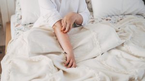 Sensitive skin allergic concept, Woman itching on her arm have a red rash from allergy symptom and from scratching.