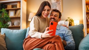 Una pareja se divierte observando el móvil