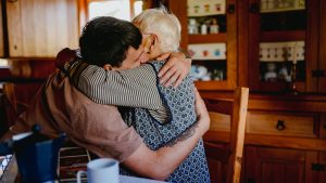 Anciana y chico se dan un abrazo // Getty